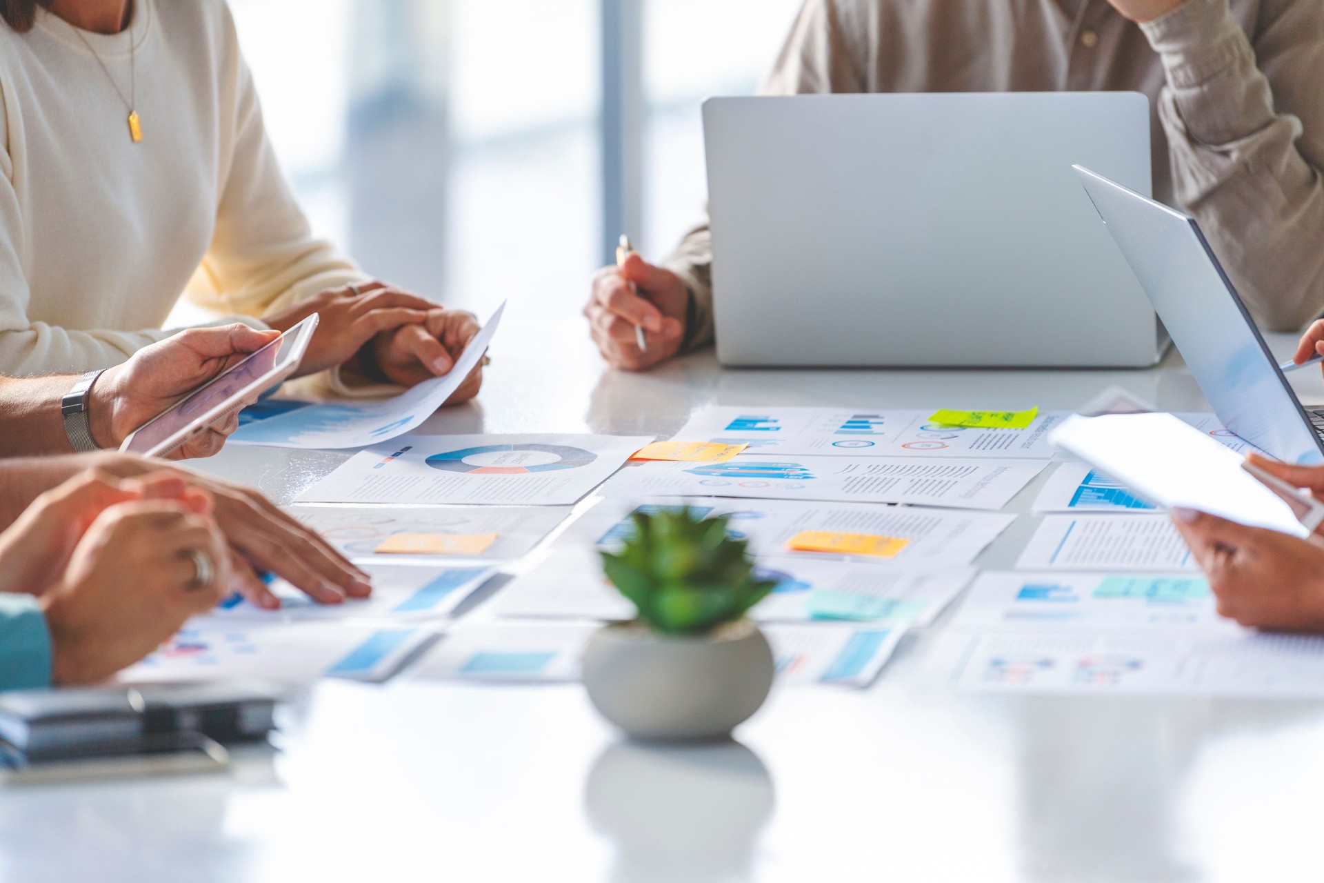 Multi racial group of people working with Paperwork on a board room table at a business presentation or seminar.